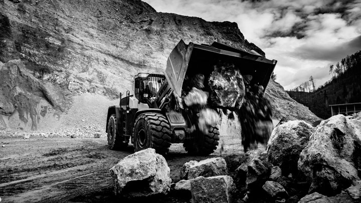 A front-end loader loading off some hard rocks with a bucket made in Hardox® wear plate.