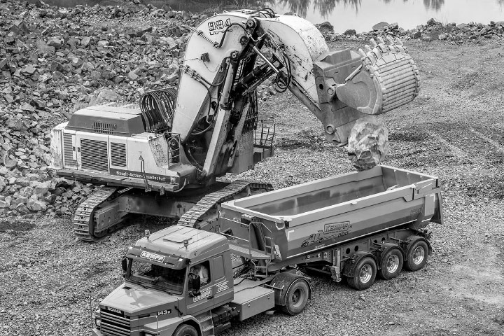 Un excavator încarcă într-o basculantă realizată din oțel Hardox® 450 rezistent și durabil