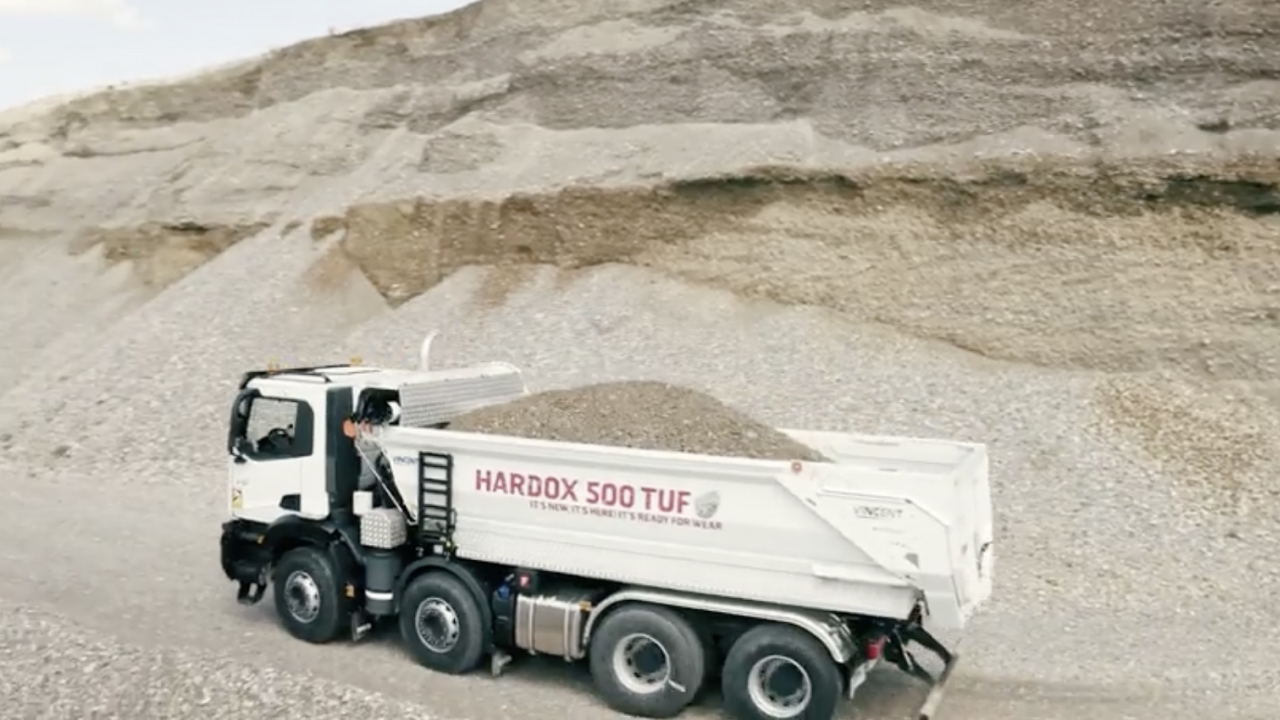 Camion minier transportant des roches abrasives, avec une carrosserie portant le logo Hardox® 500 Tuf.
