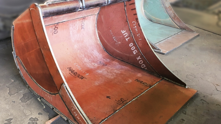 The Hardox® 500 Tuf name printed all over the inside of a strong and tough steel digging bucket made by excavator bucket manufacturer ChangWoon.
