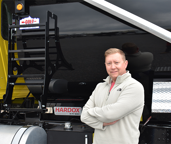 The general manager of Industrial Welding Supply standing in front of a Colt-branded and Hardox® in My Body-certified custom truck body.