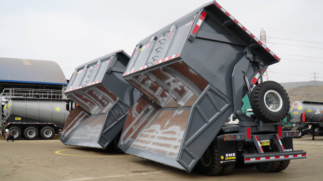 Close-up of two gray dump truck bodies made in Hardox® steel, with their bottoms open. 