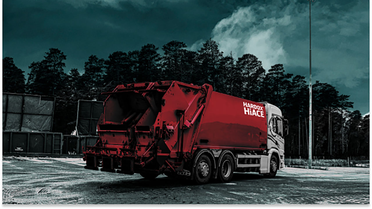 Deep red waste truck with the Hardox® Hi Ace logo.