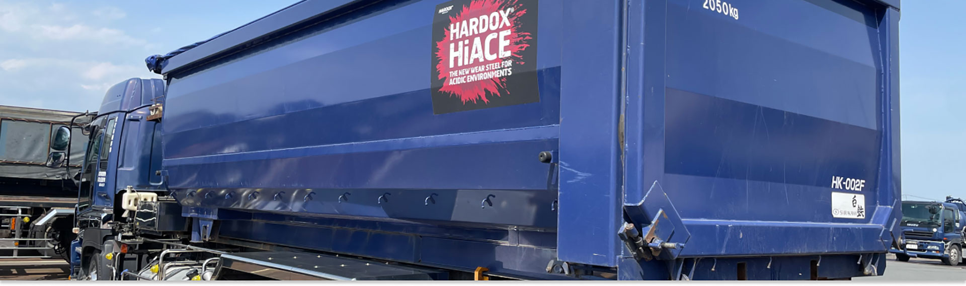 深蓝色卡车，车身采用悍达® HiAce 钢材制成，适用于腐蚀性环境。