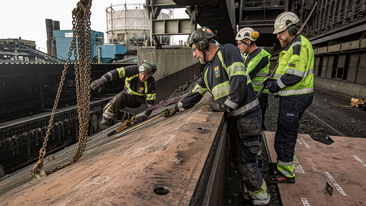 Workers in hard hats inspecting a sliding ramp made in Hardox® HiTemp at a steel mill in Oxelösund, Sweden.