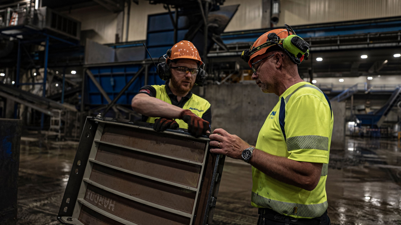 Two men in a workshop inspecting a recycling drum grid segment made of high-strength, corrosion resistant Hardox® HiAce steel. 