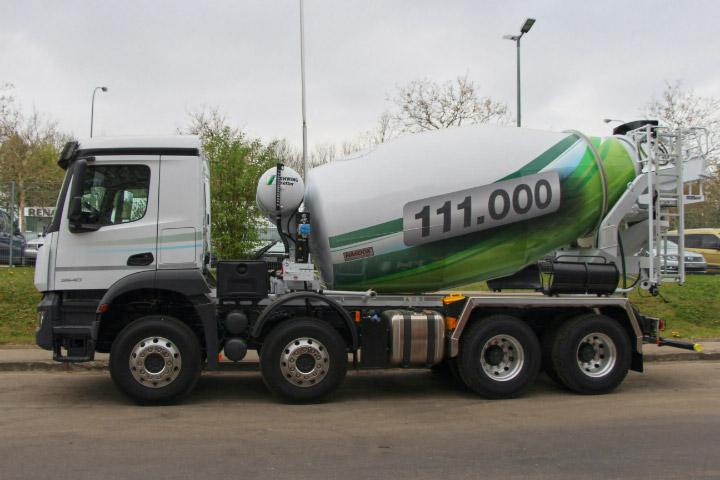 En betongbil med blandartrumma tillverkad av Hardox® slitstål på vägen.