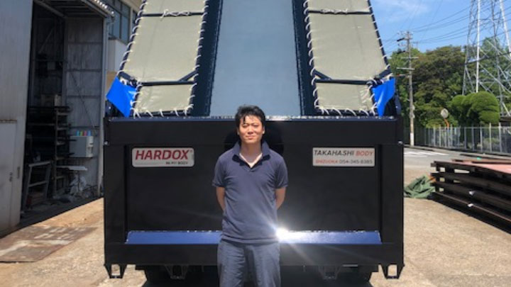 Masataka Takahashi, sales director at Japanese Takahashi Body, proudly standing in front of a Hardox® In My Body certified tipper.