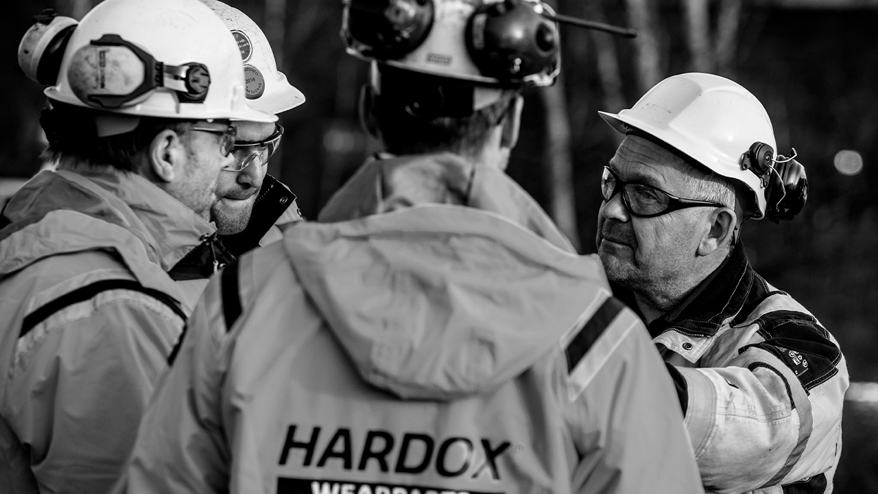 A group of workers in Hardox Wearparts jackets and hardhats