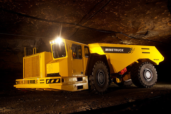 Yellow mine truck with parts made in Hardox wear plate, down in a dark underground mine