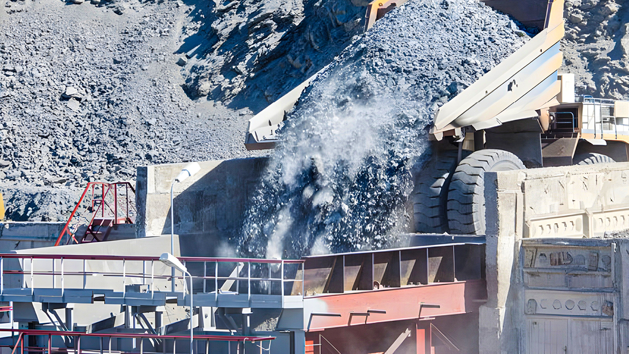 A mining site with a mining haul truck dumping a load of abrasive rocks.