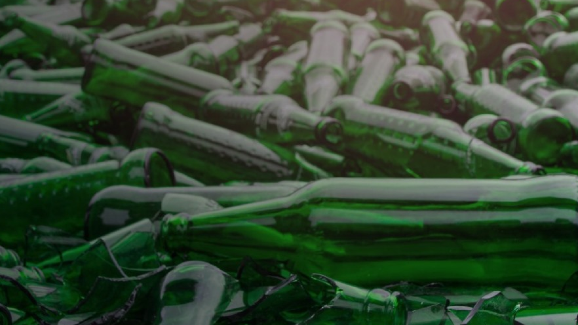 A bunch of green glass bottles waiting to be recycled.