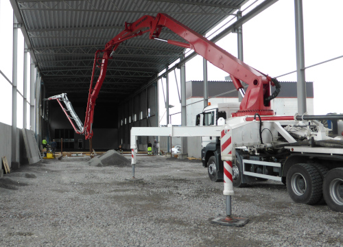 Bright red boom on a slurry truck with parts that use abrasion resistant steel pipe and tube in Hardox® steel