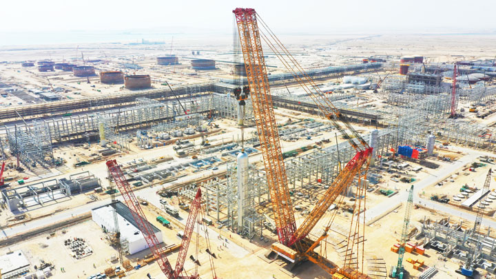 A giant crawler crane with tension bars in Strenx® steel performing a hoisting operation at the Dugm Oil Refinery of Oman.