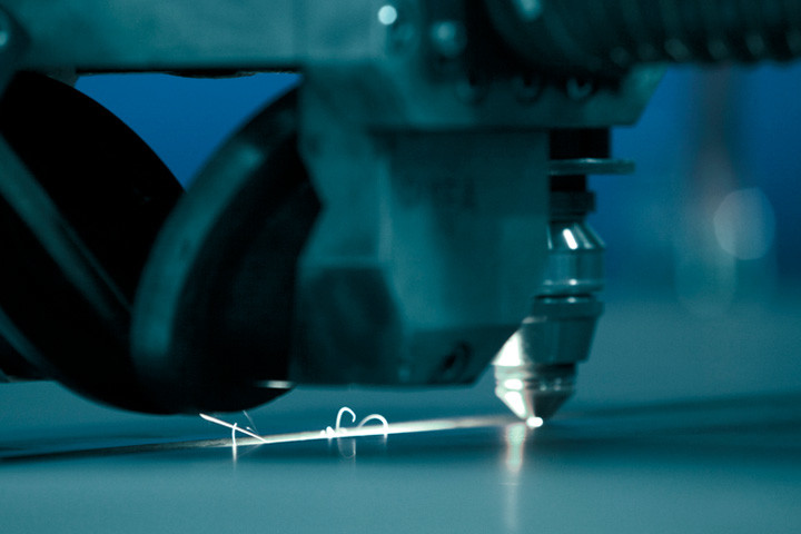 A laser cutting head cuts a plate of Strenx steel.